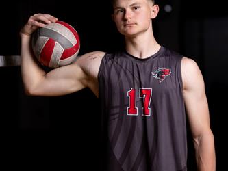 Volleyball player posing with ball on bicep