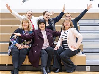 staff posing on bleachers