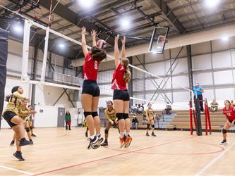 Futures Girls Volleyball team defending the net