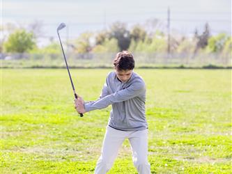 Golf player swinging ball