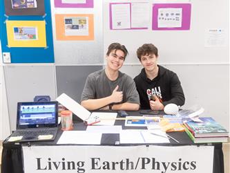 Two students are sat down at their living earth & physics display