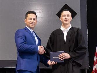 Principal posing with graduating senior