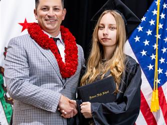 futures principal shaking hands with graduating student