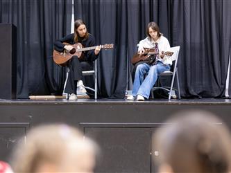 Students playing guitar on stage