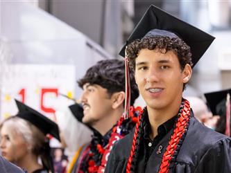 assistant principal handing diploma to graduate 