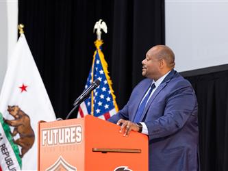 superintendent shaking principals hand on stage 