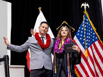 student hugging principal at graduation