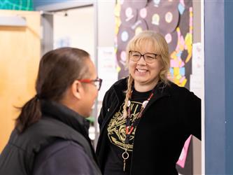 A teacher is happily greeting guests at the event