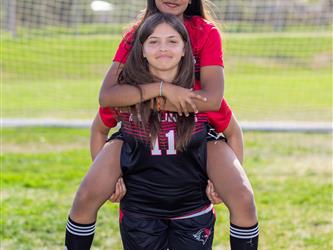 Girls soccer team players piggyback riding
