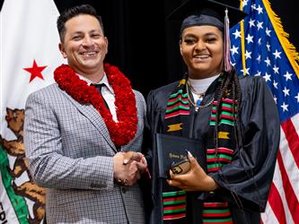 futures principal shaking hands with graduating student