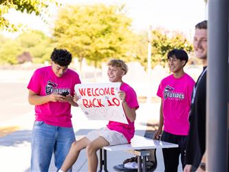 students greeting with a sign 