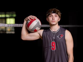 Volleyball player posing with ball on bicep