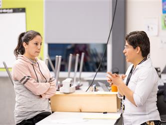 A teacher is engaged in conversation with a student