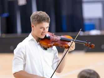 Student on stage playing violin
