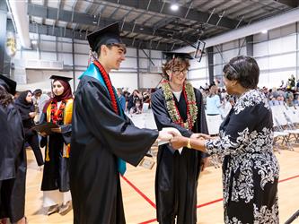 futures principal shaking hands with graduating student