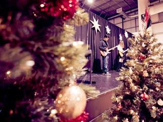 Guitar player on stage with christmas trees